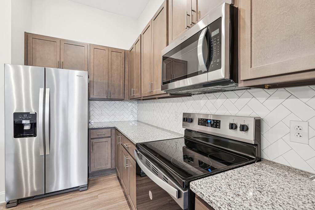 A modern kitchen with a stainless steel refrigerator, microwave, and oven.at The Parker Leland, Leland, NC 28451  