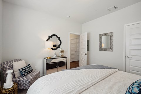 Bedroom with a bed and a chair and a mirror  at The Meadows, Bloomingdale, GA, 31302