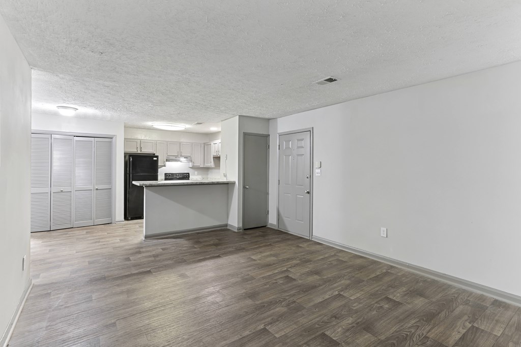 A room with a kitchenette and a door.