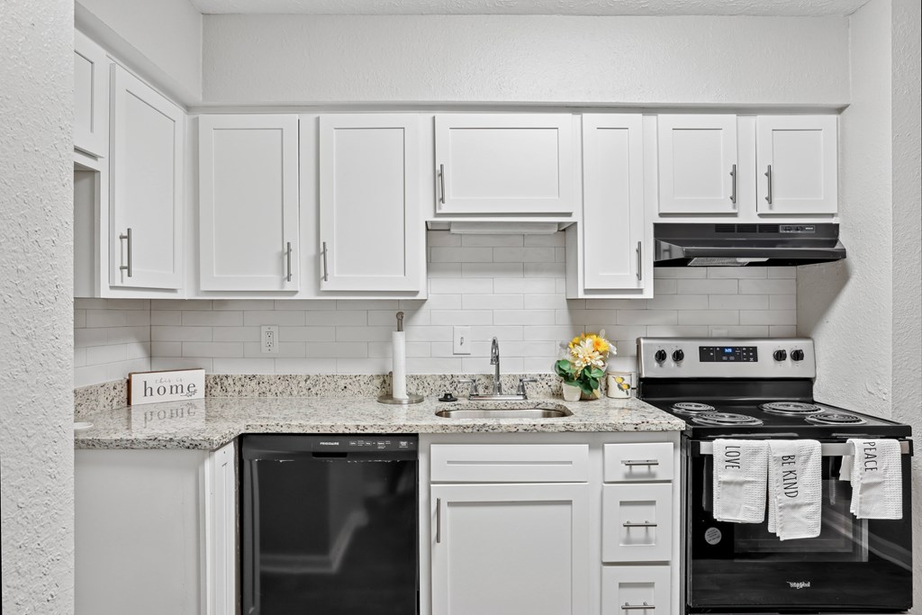 A kitchen with white cabinets and appliances.