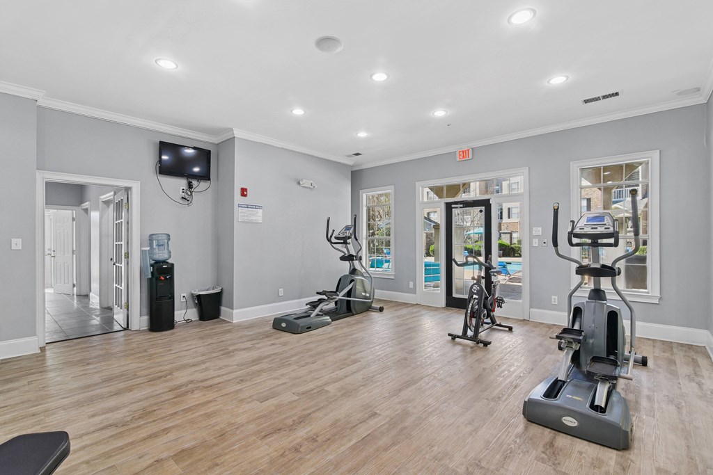 A spacious room with a treadmill, exercise bike, and other workout equipment.