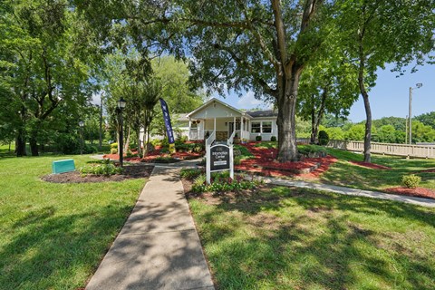 A house is surrounded by a green lawn and trees.