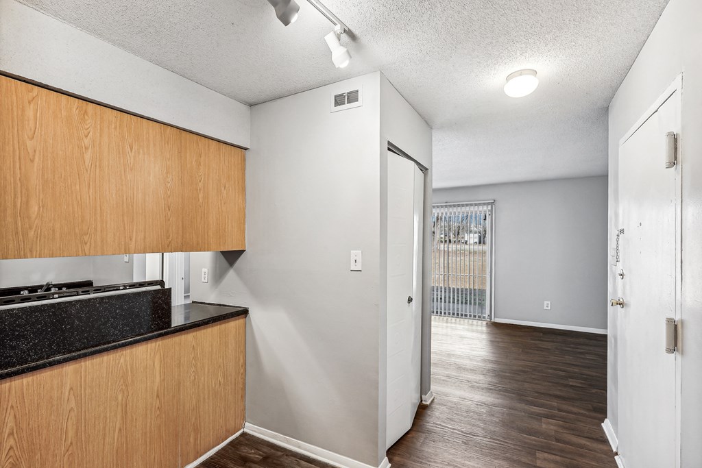 the kitchen and living room of a renovated apartment with wood flooring and white walls