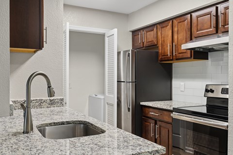 A kitchen with a sink and a refrigerator.
