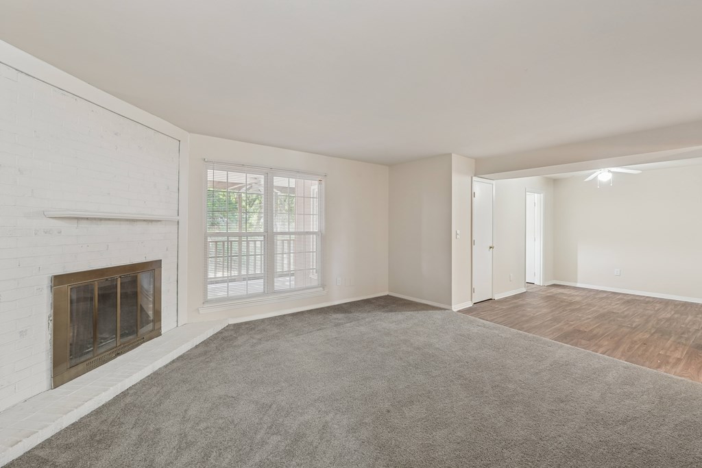 A room with a fireplace and a carpeted floor.
