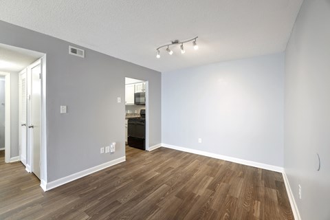 an empty living room with wood flooring and a door to a kitchen  at Governors House, Huntsville, 35805