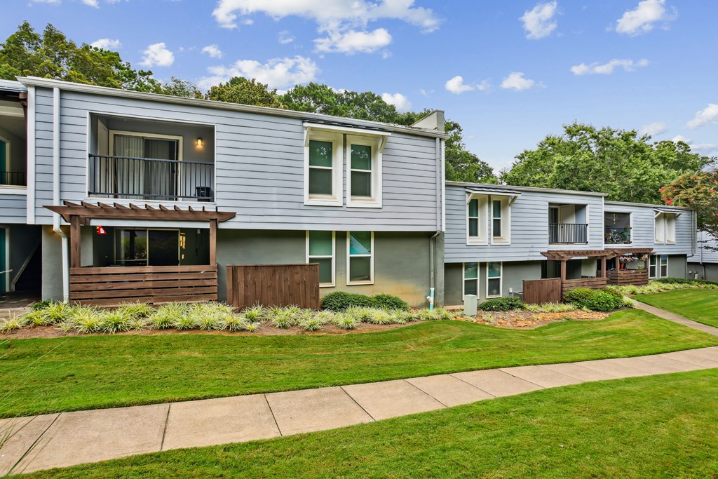 A row of houses with green lawns in front.