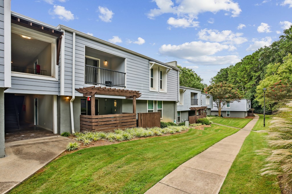 A row of houses with a green lawn in front.