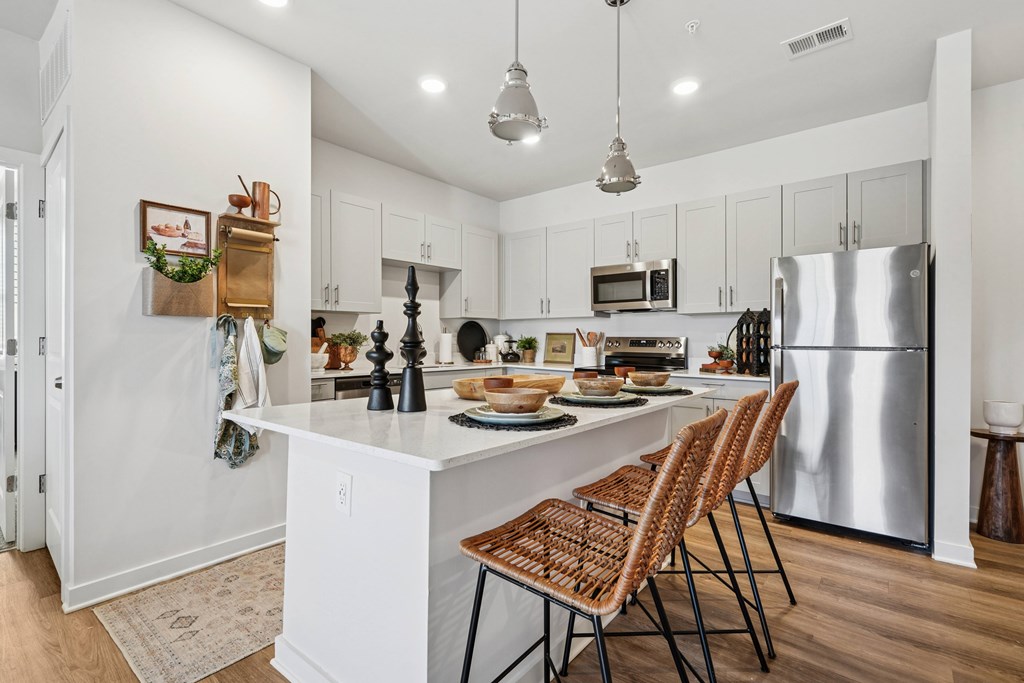 A kitchen with a white island and a refrigerator.