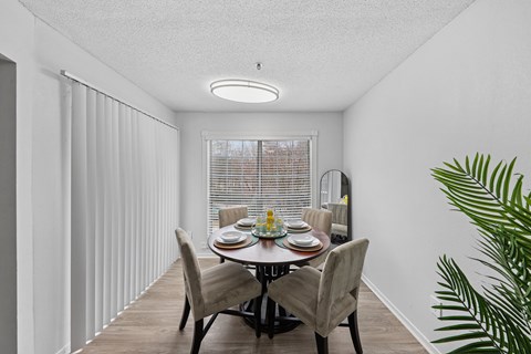 A dining room with a table set for four.