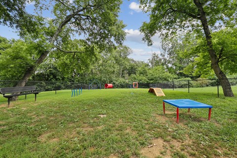 A playground with a blue table and a red object in the background.
