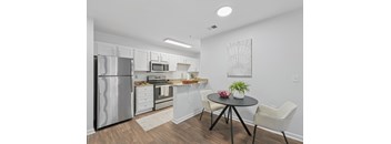 A kitchen with a refrigerator, oven, and sink.