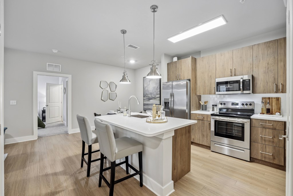A modern kitchen with a dining table and chairs.at The Exchange at Crestview Apartments, Crestview, Florida
