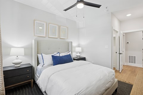 A bedroom with a large bed, a ceiling fan, and a nightstand with a lamp at Union Eleven Apartments, Atlanta, 30324