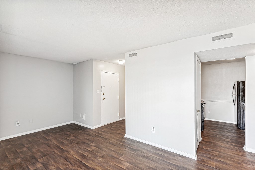 a living room with a hard wood floor and white walls