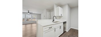 A kitchen with white cabinets and a sink.
