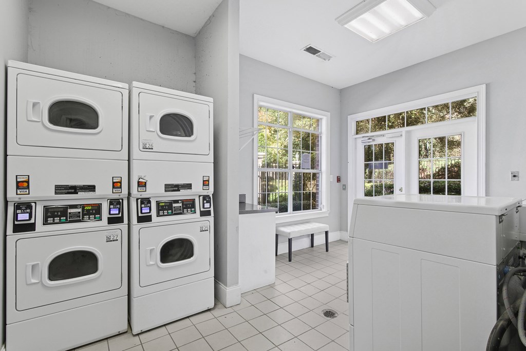 A laundry room with two washing machines and a bench.