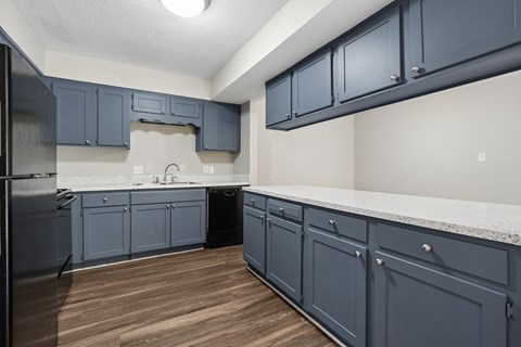 A kitchen with dark blue cabinets and a white countertop.