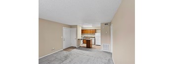 A kitchen area with a refrigerator, cabinets, and a countertop.