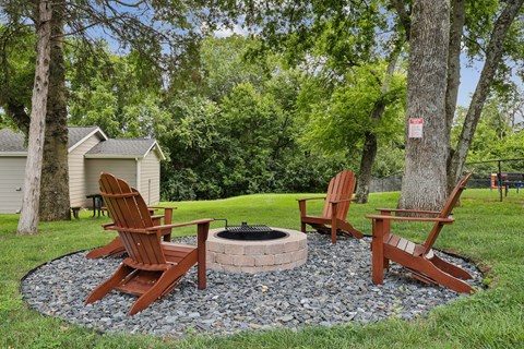 Two chairs and a fire pit in a backyard.