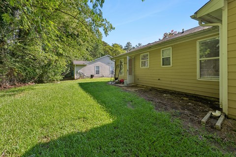 A yellow house with a green lawn in front.