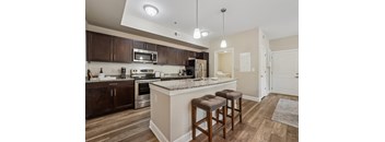 A kitchen with a bar area and two stools.