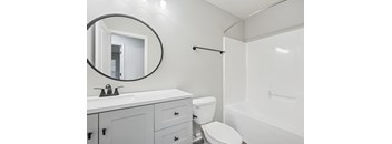 A white bathroom with a toilet, sink, and bathtub.