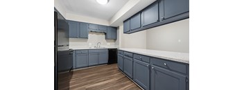 A kitchen with dark blue cabinets and a white countertop.