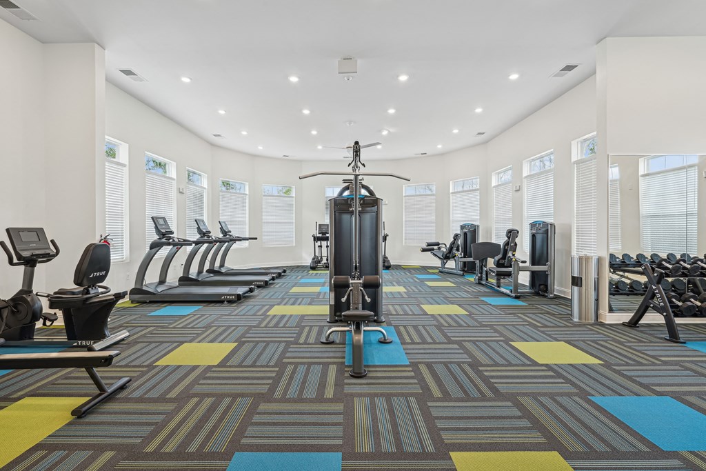 A gym with a variety of equipment including treadmills, weights, and exercise machines.at The Parker Leland, Leland, NC 28451  