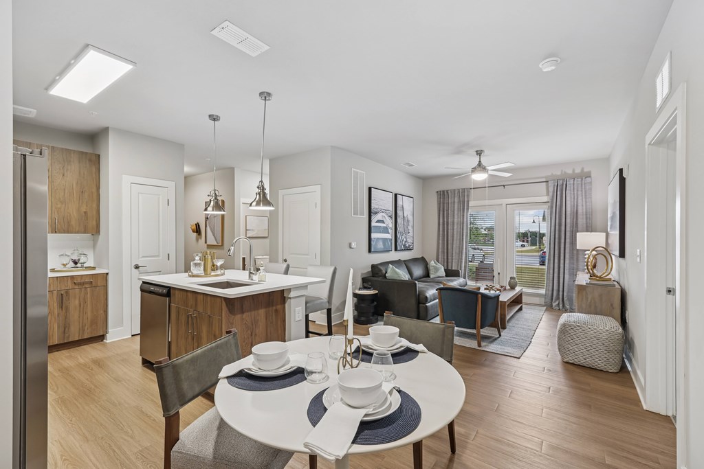 A modern kitchen with a dining table set for two.at The Exchange at Crestview Apartments, Crestview, FL, 32536
