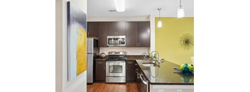 A modern kitchen with a stainless steel refrigerator and a stove top oven.