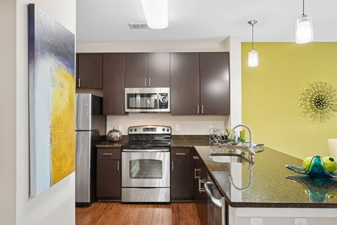 A modern kitchen with a stainless steel refrigerator and a stove top oven.