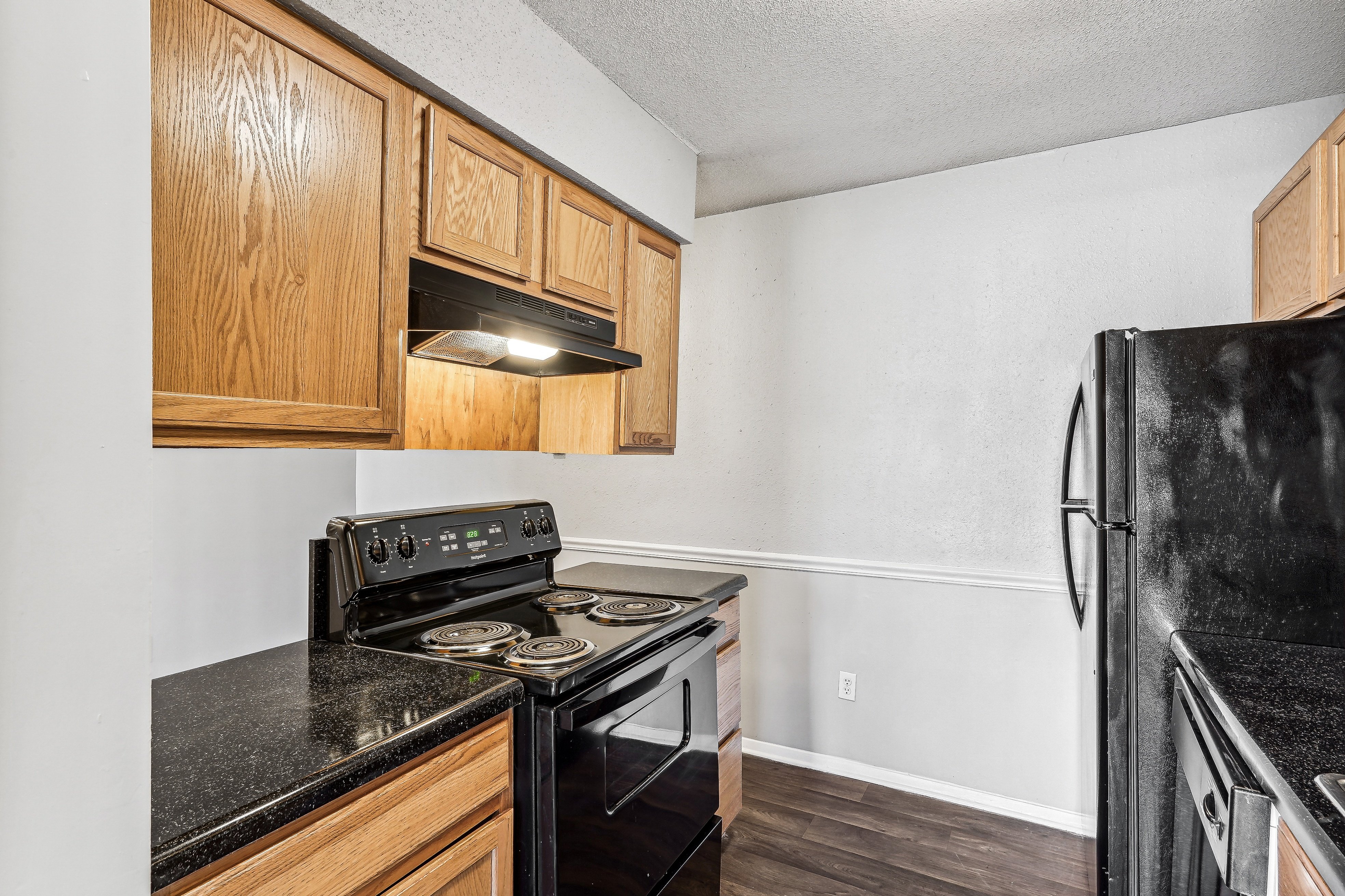 the kitchen of our studio apartment atrium with black appliances and wood cabinets