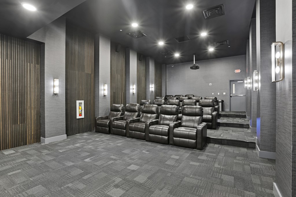 A row of black leather chairs are lined up in a room.