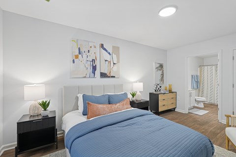 A bedroom with a large bed and a painting on the wall.