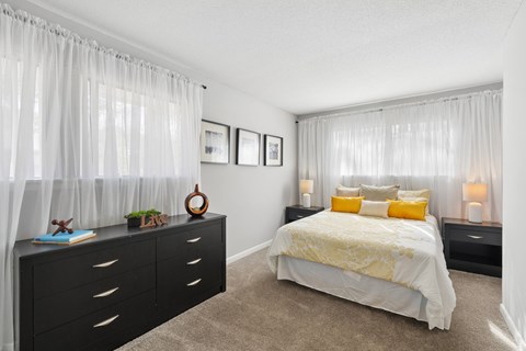 Bright bedroom with sheer curtains and yellow accents at Emory Woods Apartments, Durham, 27713