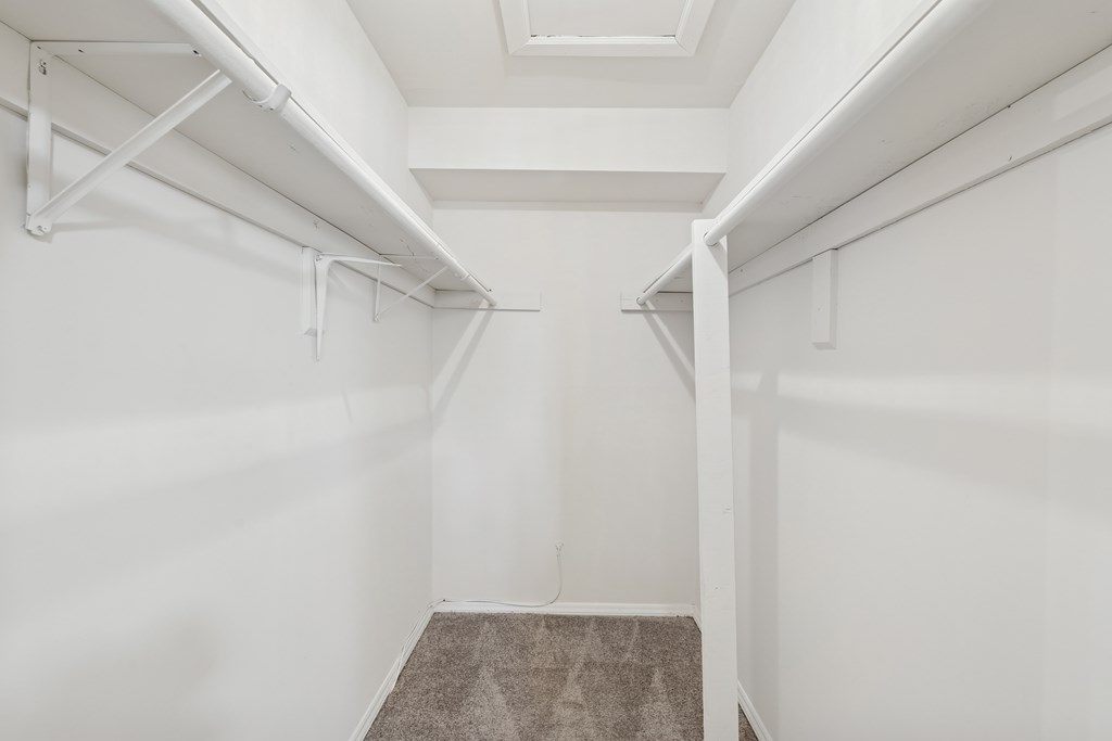 A white hallway with a carpeted floor and white walls.