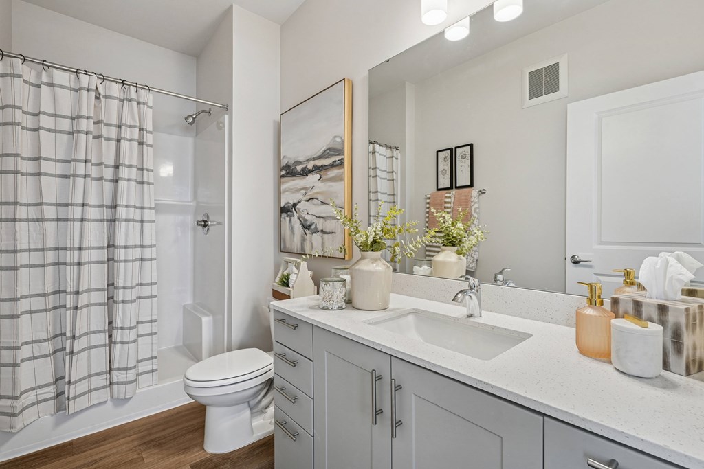 A bathroom with a toilet, sink, and shower.
