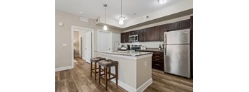 A kitchen with a white counter top and a stainless steel refrigerator.