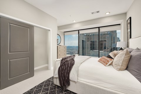 A bedroom with a large bed and a view of the city.