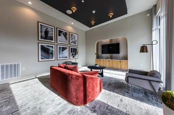 a living room with a red couch and a tv at The Monroe Apartments, Texas, 78741