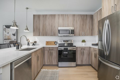A modern kitchen with wooden cabinets and stainless steel appliances.