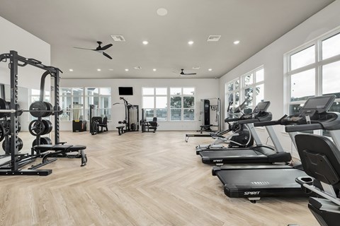 A spacious gym with treadmills, weights, and exercise equipment at The Exchange at Crestview Apartments, Florida, 32536