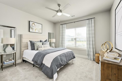 A bedroom with a large bed and a ceiling fan at The Exchange at Crestview Apartments, Crestview, FL