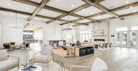A spacious living room with a fireplace and a dining table set up at The Exchange at Crestview Apartments, Crestview, Florida