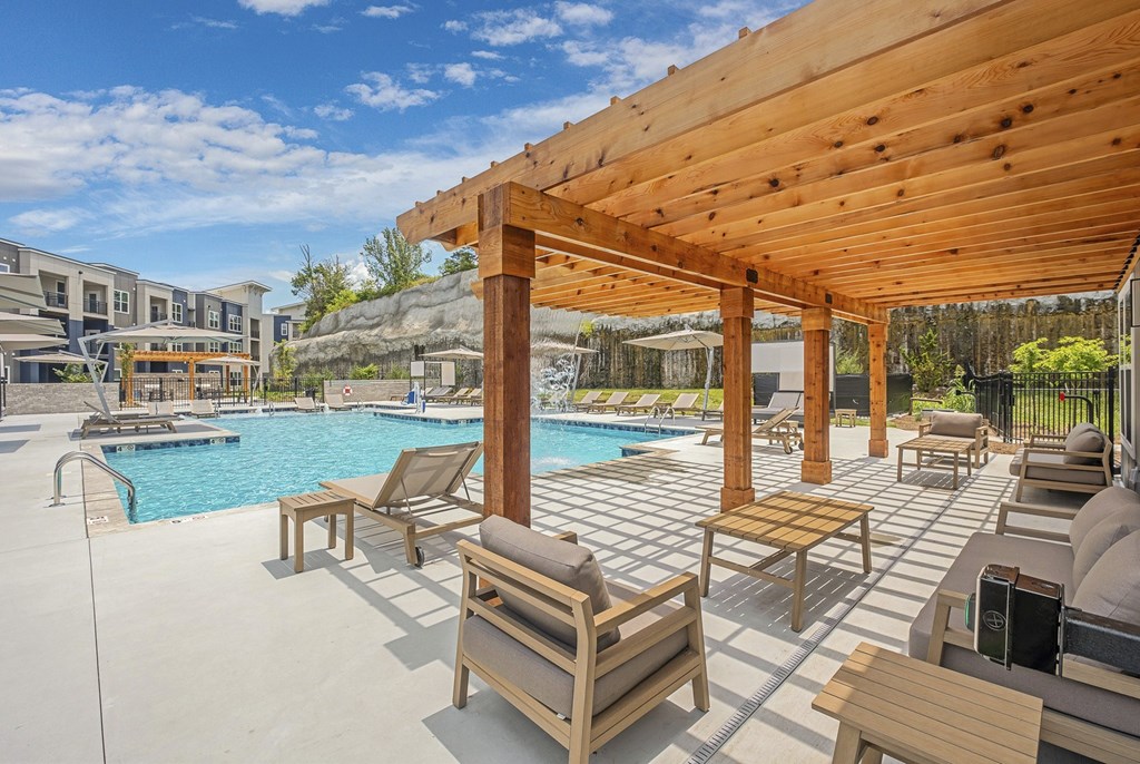 A wooden pergola over a pool with sun loungers at The Percy Apartments, Nashville, TN