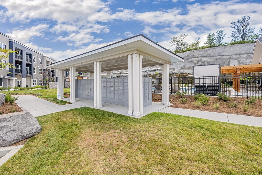A small white pavilion with a grey roof is surrounded by a grassy area at The Percy Apartments, Tennessee