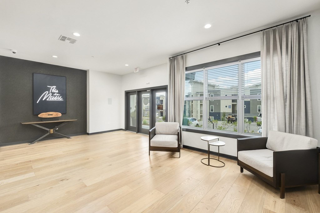 A living room with a couch, chair, and a sign at The Percy Apartments, Nashville, Tennessee