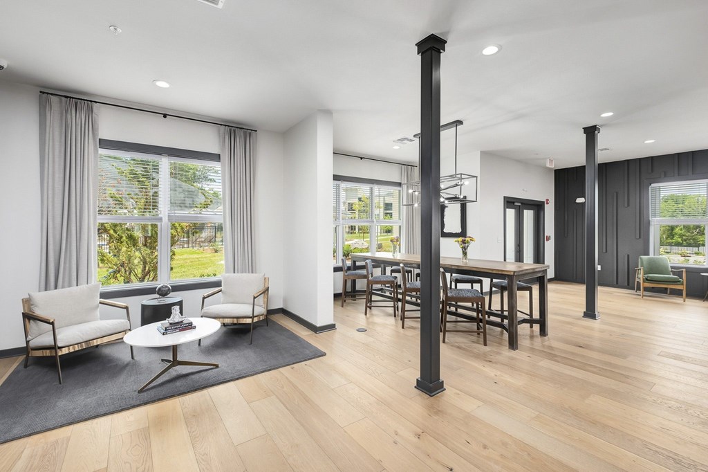A modern living room with a white sofa, a black table, and a wooden floor at The Percy Apartments, Nashville, 37214
