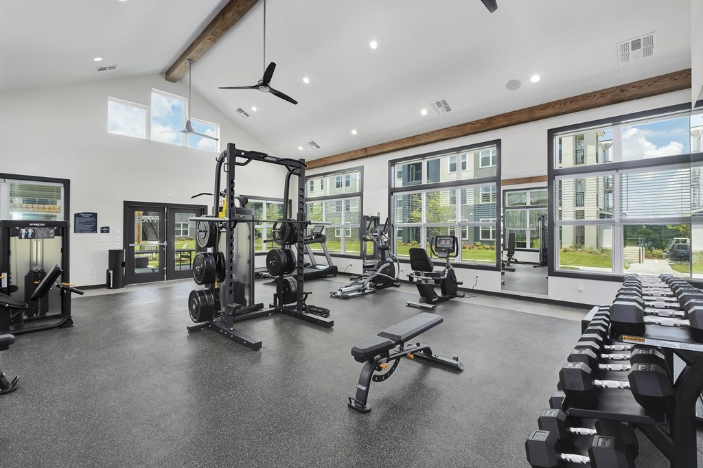 A spacious gym with a variety of equipment and a view of the outside at The Percy Apartments, Nashville, Tennessee